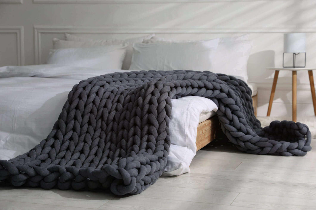 Weighted blanket in chunky knit design on bed for better sleep