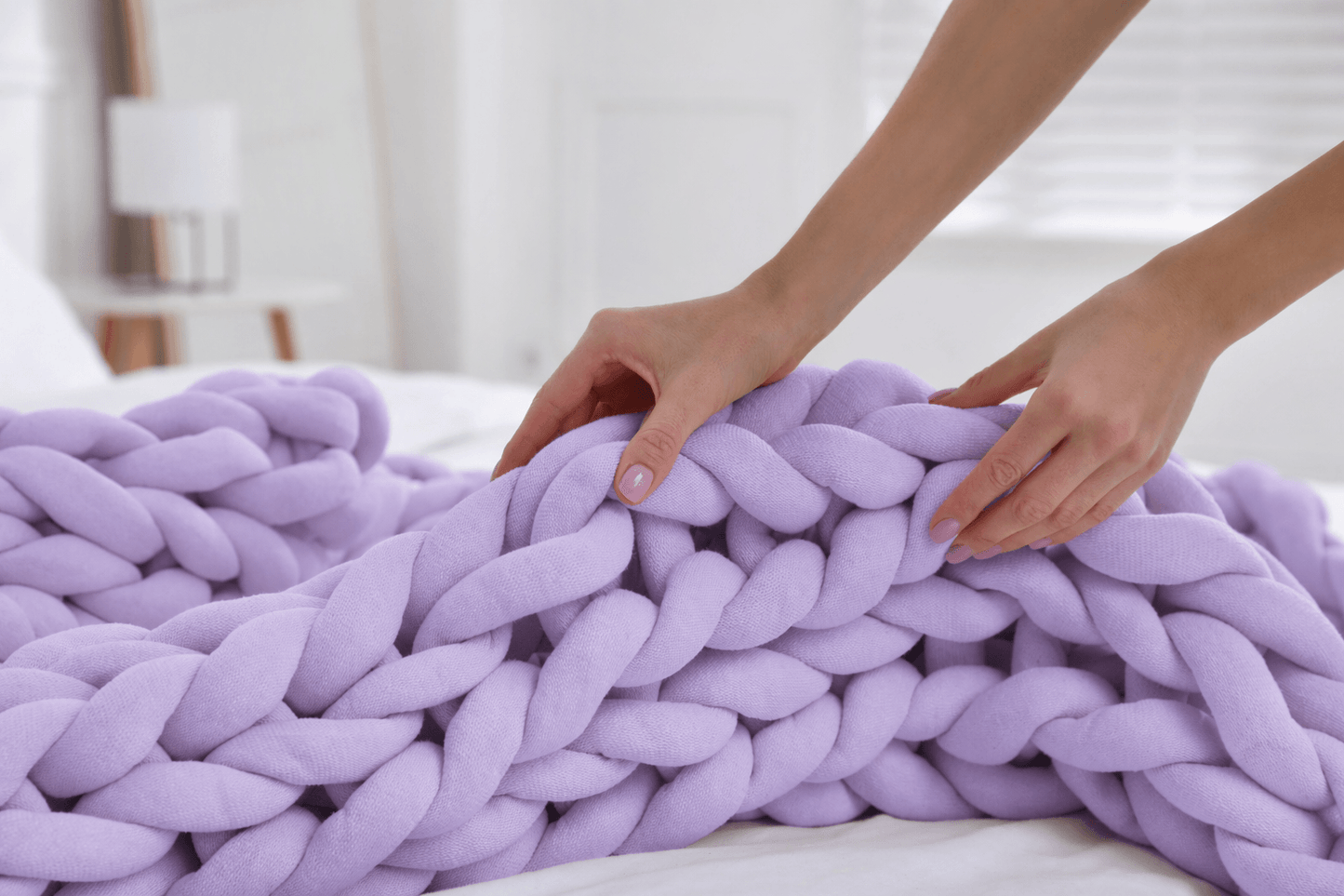  BloomKnit™ Chunky Cotton Weighted Blanket in Lilac Veil on a bed, showcasing its soft and luxurious texture.