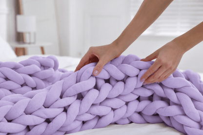  BloomKnit™ Chunky Cotton Weighted Blanket in Lilac Veil on a bed, showcasing its soft and luxurious texture.