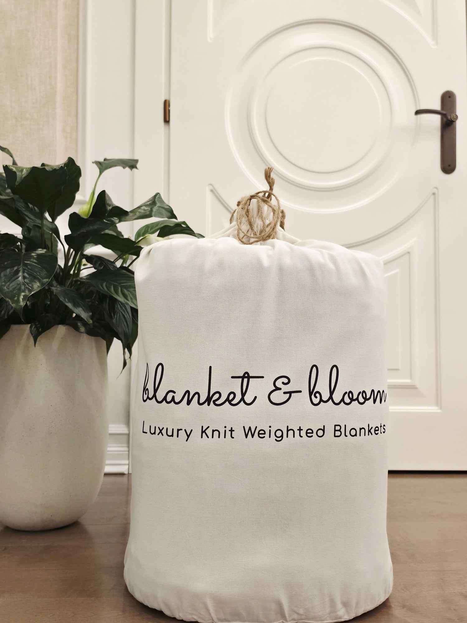 Blanket & Bloom luxury cotton weighted blanket in a white muslin storage bag with modern home decor.