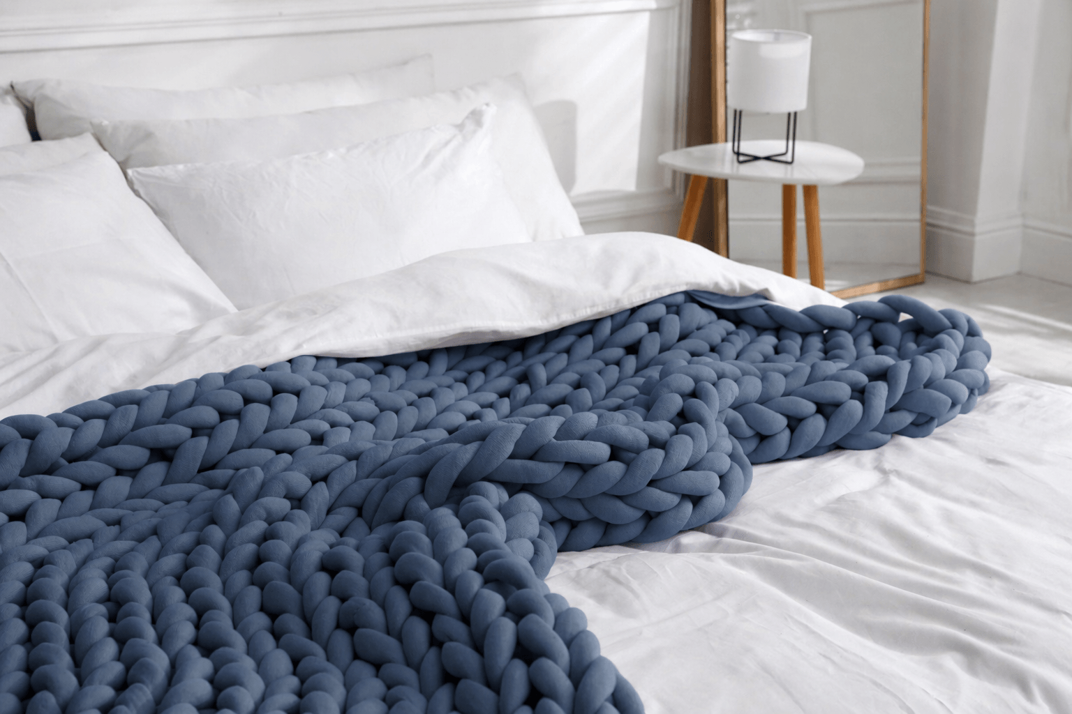 BloomKnit™ chunky cotton weighted blanket in Slate draped on a bed