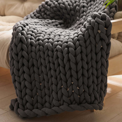 BloomKnit™ chunky knit weighted blanket in Midnight Ash™ draped over an armchair | midnight-ash