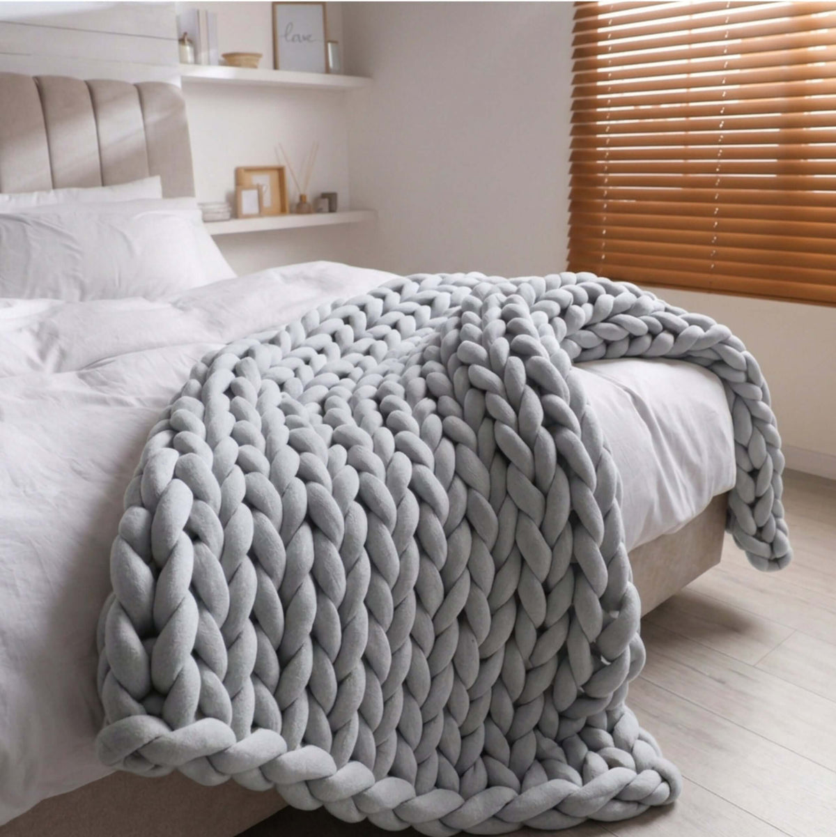 BloomKnit chunky cotton knitted weighted blanket in cloudstone, folded on a bed| cloudstone